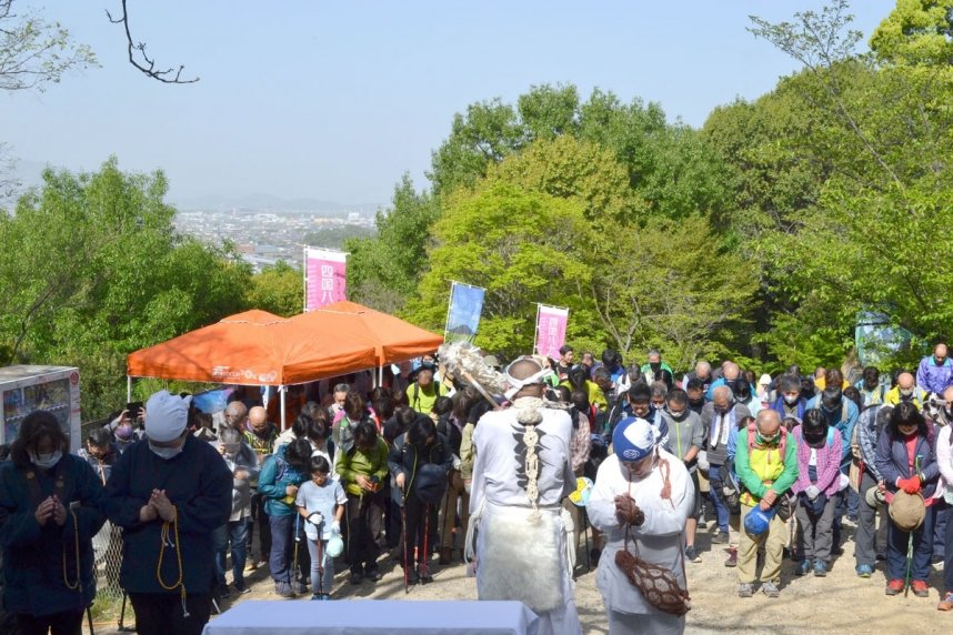 山開き式で僧侶と一緒に安全を祈願する登山者＝香川県丸亀市飯野町